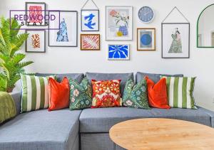 a living room with a gray couch with colorful pillows at Comfortable and Homely 1-Bedroom 1-Bathroom Serviced Apartment with Free Parking, Free WiFi By Redwood Stays in Farnborough