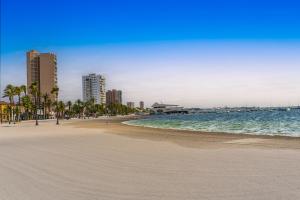 una playa con palmeras, océano y edificios en Villa La Paz, en San Javier