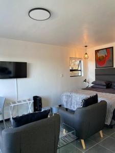 a bedroom with a bed and two chairs and a couch at 31Ridge Road in Durbanville