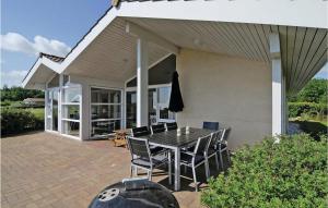 ein Haus mit einem Tisch und Stühlen auf einer Terrasse in der Unterkunft Holiday Home Hvedemarken Sjølund I in Hejls