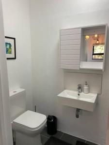 a white bathroom with a toilet and a sink at 31Ridge Road in Durbanville