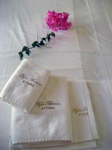 two white napkins with a pink flower on a table at Fyri Ammos Residences in Agia Pelagia Kythira