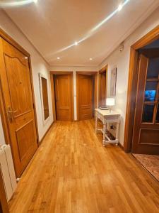 an empty room with a wooden floor and a table at La casita de Carmen in León