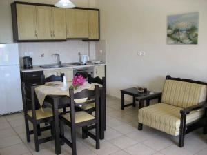 a kitchen with a table and chairs and a refrigerator at Fyri Ammos Residences in Agia Pelagia +27 photos