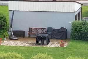 a patio with a table and a bench in a backyard at Fin lägenhet i Ulricehamn nära Lassalyckan in Ulricehamn