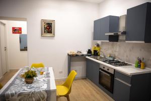 a kitchen with a table and yellow chairs at Filo Apartment in Capua