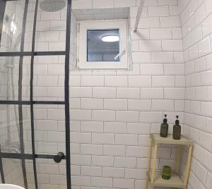 y baño con ducha de azulejos blancos y ventana. en Downtown mountain view two bedroom apartment 4th floor, en Gura Humorului 7 fotos más