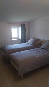 two beds in a bedroom with a window at Maison à la campagne in Les Brouzils