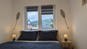 Un dormitorio con una cama y una ventana grande. en Downtown mountain view two bedroom apartment 4th floor, en Gura Humorului