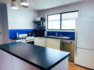 a kitchen with a black counter top and a refrigerator at The Lighthouse in Point Turton