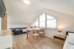 a small room with a table and a bed at Pokoje i Domki DRAGA in Jastarnia