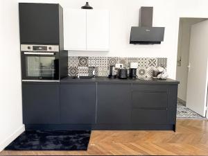 a kitchen with a black counter top and a stove at Studio Napoléon - N3 in Alençon