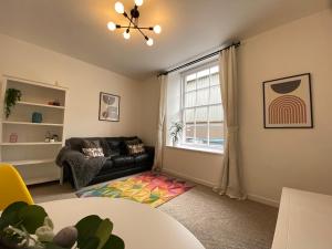 a living room with a couch and a window at Quay Apartment with parking in Aberdeen