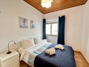 a bedroom with a bed with two towels on it at Ericeira Apartments in Ericeira