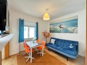a living room with a blue couch and a table at Ericeira Apartments in Ericeira