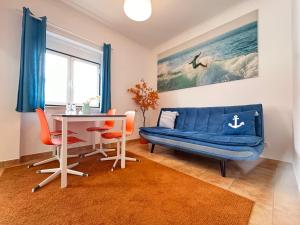 a living room with a blue couch and a table at Ericeira Apartments in Ericeira