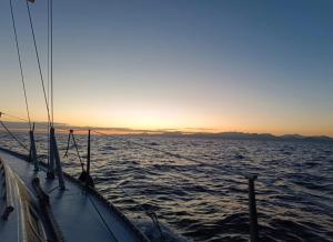 a boat in the ocean with the sunset in the background at Velero Puma 32 in Caleta de Sebo