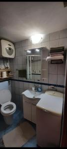 a bathroom with a toilet and a sink and a mirror at Grika apartment in Split