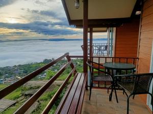 a balcony with a table and chairs and a view at Nuea Tawan at Phu Thap Buek in Ban Tha Kok Hai
