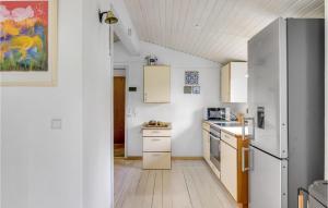 a kitchen with white cabinets and a refrigerator at Awesome Home In Jægerspris With Kitchen in Jægerspris