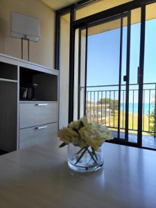 a vase of flowers on a table with a view at Illinois Beach Hotel in Zion