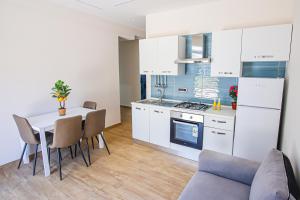 a kitchen with white cabinets and a table and chairs at Villa Teresa Relax in Corbara
