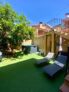 a yard with two chairs and an umbrella at CASA LAS HERRERA in Casavieja