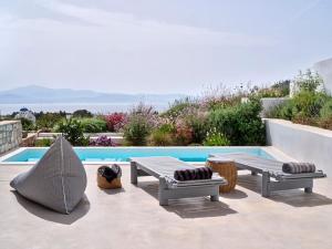 a patio with two benches and a swimming pool at Lavender House in Kampos Paros