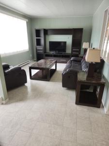 a living room with a couch and a table at Appartement de la rive in Shippagan