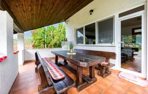 a patio with a wooden table and a bench at Amazing Home In Fericanci With Sauna in FeriÄanci