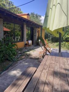 a wooden deck with a bench and an umbrella at Cabana da Oliveira in Marco de Canavezes +10 photos