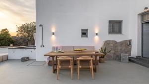 a patio with a wooden table and chairs at Sunset Villa in Plaka Milou