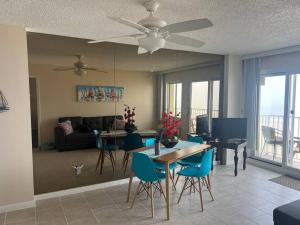 a living room with a table and blue chairs at Oceanfront condo, ocean view and indoor pool in Virginia Beach