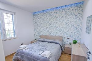 a bedroom with a bed and a blue wall at Villa Teresa Relax in Corbara