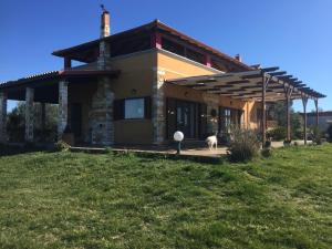 a house with a dog standing in front of it at Il TRAMONDO in Néa Thésis