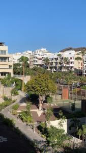 Blick auf einen Park mit Bäumen und Gebäuden in der Unterkunft Apartamento Las Palmeritas Palm Mar Tenerife Sur in Palm-mar