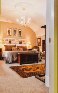 una camera da letto con un letto e un lampadario di Lyne House Ideal for a celebration or reunion a Kidlington