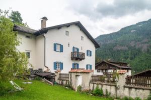 una casa bianca con finestre blu e un cortile verde di Chateau Ciasa Soldà Luxe Marmolada a Vigo di Fassa