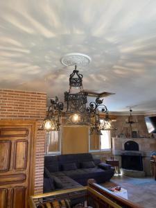 a living room with a couch and a chandelier at Casa Pascual in San Pedro del Arroyo