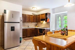 una cucina con un tavolo di legno e un frigorifero di Chateau Ciasa Soldà Luxe Marmolada a Vigo di Fassa