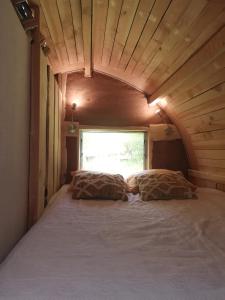 a bedroom with a large bed in a tiny house at La Verdine in Lacaze