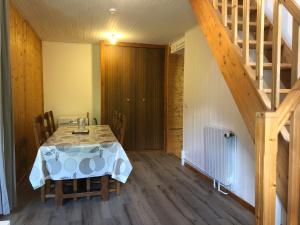 a dining room with a table and a staircase at Au Cœur des montagnes in La Chalp