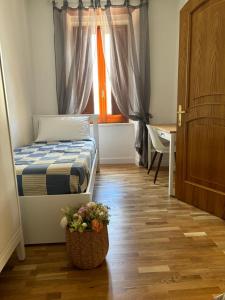 a bedroom with a bed and a pot of flowers on the floor at Amas Apartment in Fondi