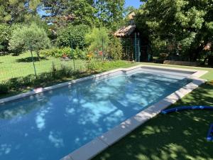 a swimming pool in a yard with a garden at Mas Valentine in Roquemaure
