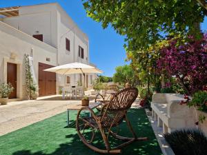 a group of chairs and an umbrella on a lawn at Residenza "I Tre Carrubi " in Fasano