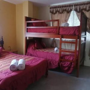 a bedroom with two bunk beds with towels on the bed at Green Haven Ecolodge Lligua in Baños