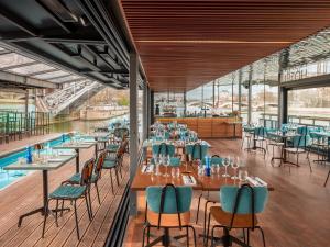 a dining room with tables and chairs and a pool at Hotel OFF Paris Seine in Paris