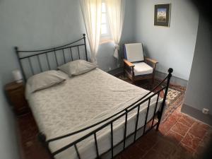 a bedroom with a bed and a chair and a window at Mas Valentine in Roquemaure