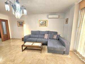 a living room with a blue couch and a table at ALMERIA CENTRO y CONFORT in Almería