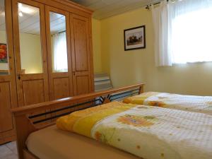 a bedroom with two beds and a mirror at Bungalow am Osterteich in Gernrode - Harz